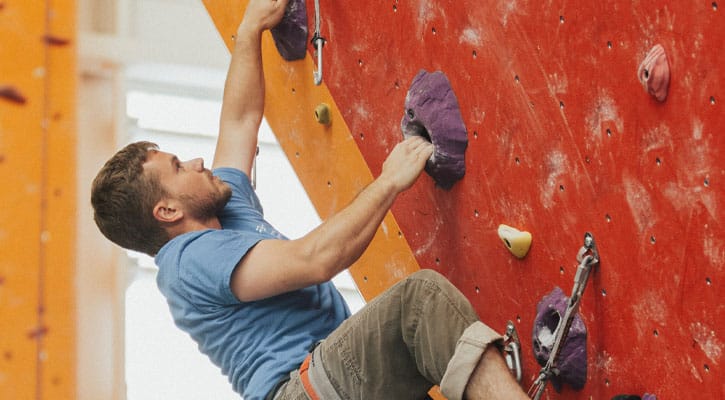 Man climbing red wall