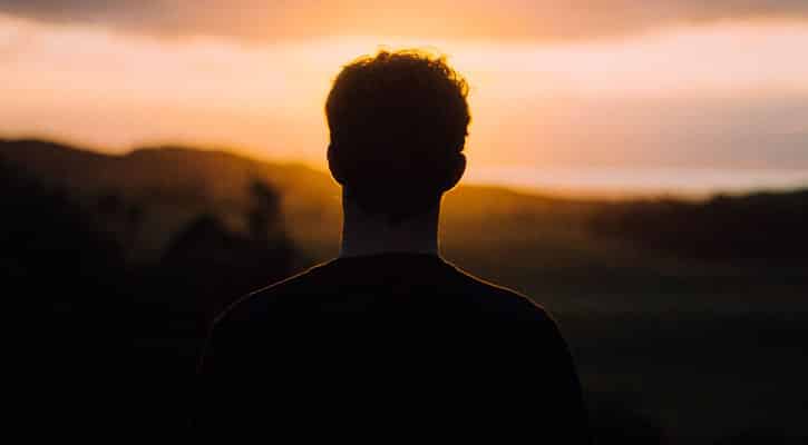 Silhouette of person looking at sunset