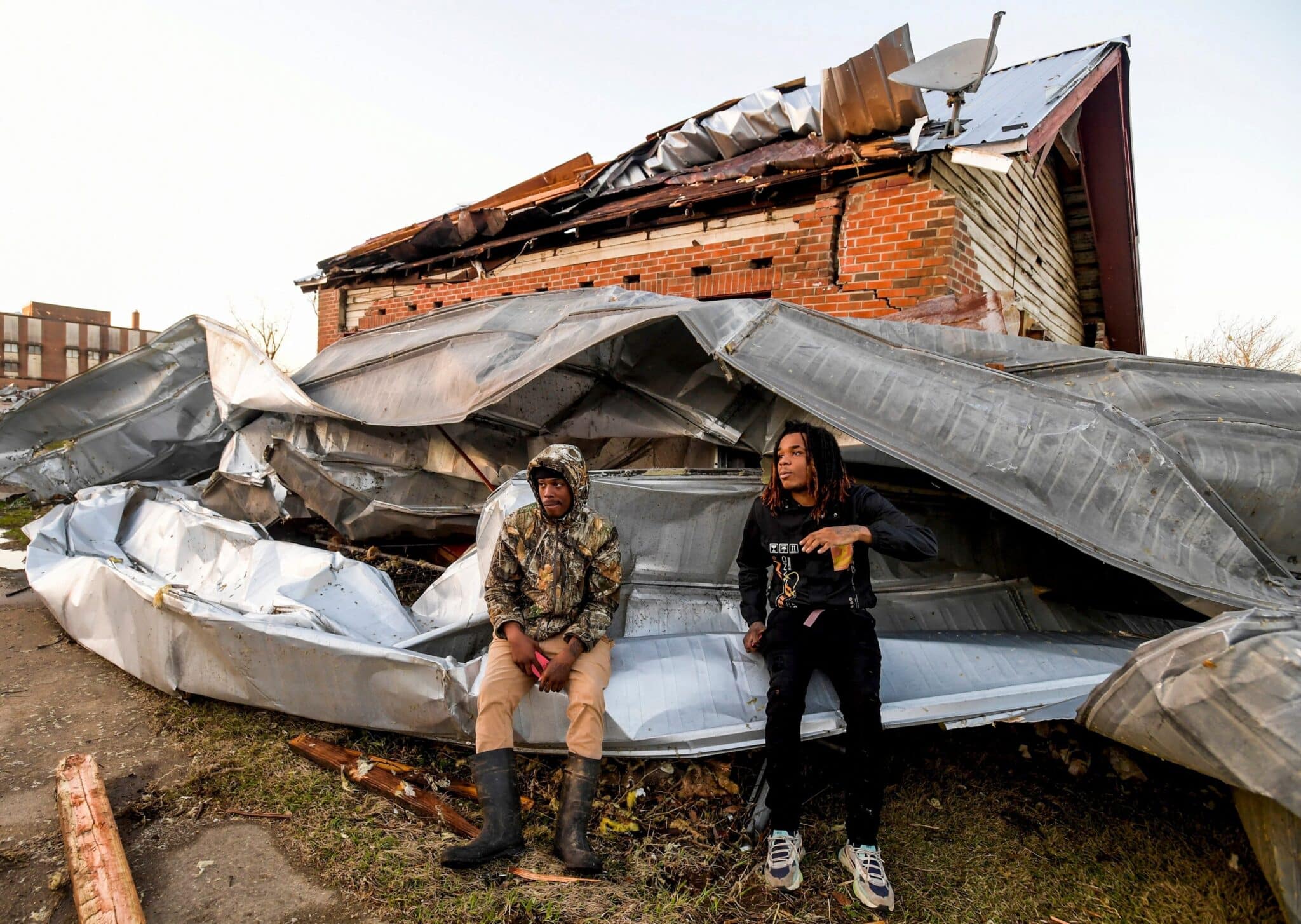 Cordel Tyus and Devo McGraw sit on roofing from an industrial building in front of their home in Selma, Ala., Jan.12, 2023, after a tornado ripped through the area the previous day. A giant, swirling storm system billowing across the South Jan. 11, killed at least six people in central Alabama, the Associated Press reported. (OSV News photo/Mickey Welsh, USA Today Network via visa Reuters)