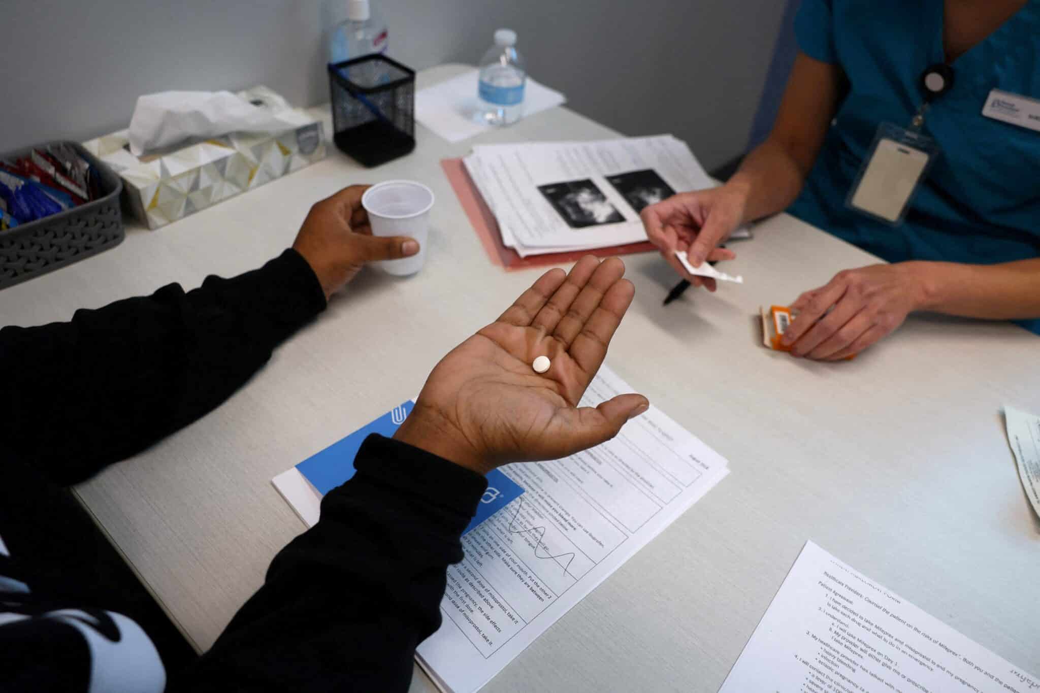 A doctor gives a patient medication to start a medical abortion at Planned Parenthood in Birmingham, Ala., March 14, 2022. An Alabama attorney general is the latest political leader to suggest prosecution for women having abortions. (OSV News photo/Evelyn Hockstein, Reuters)
