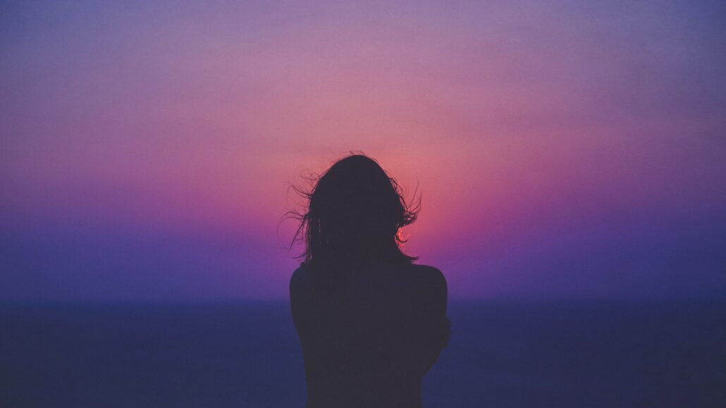 Woman looking at the sunrise | Image: Unsplash