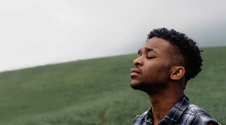 Man outdoors with eyes closed