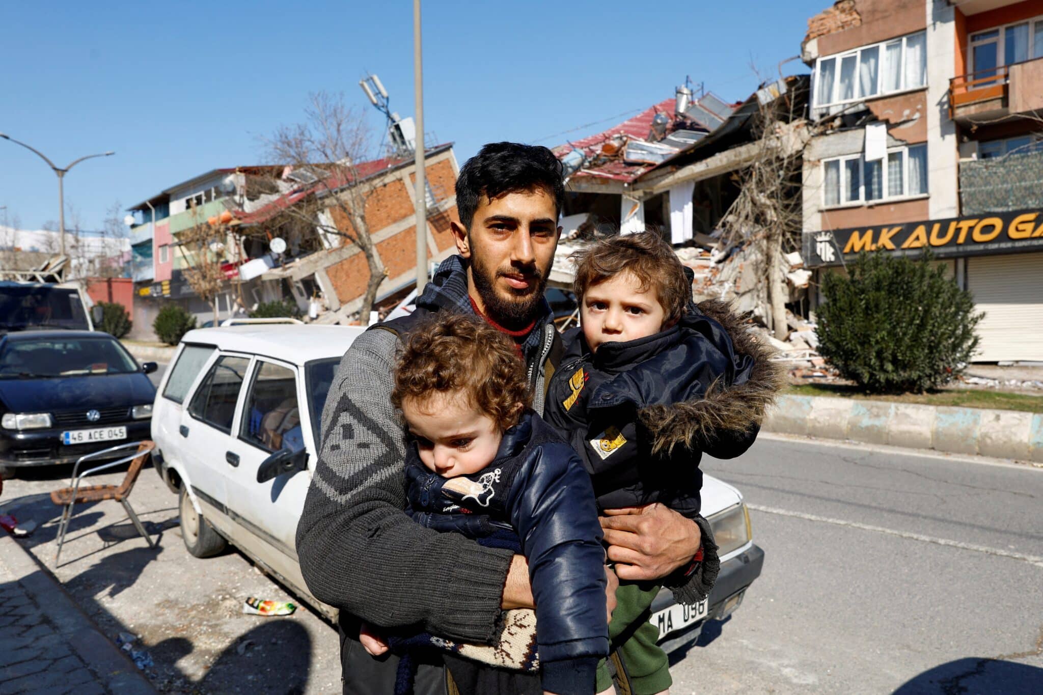 A member of a Syrian family carries children in Kahramanmaras, Turkey, Feb. 9, 2023, after his house in Turkey was destroyed in the deadly Feb. 6 earthquake. The family had moved to Turkey sometime after their house in Syria was destroyed during the war. (OSV News photo/Suhaib Salem, Reuters)