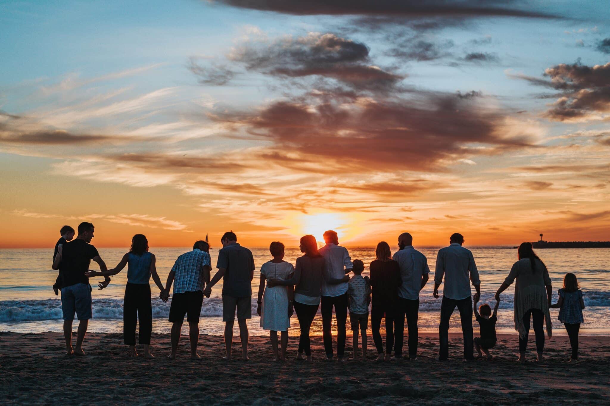 Family poses on the beach | Photo by Tyler Nix on Unsplash