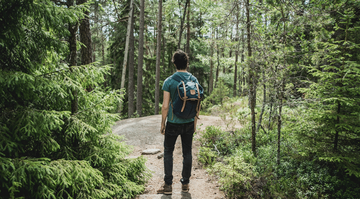 Man with backpack walking on path