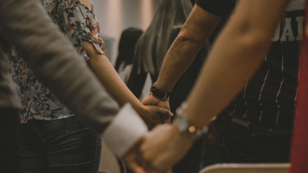 People holding hands in church | The Fruits of Prayer | Photo by Pedro Lima on Unsplash