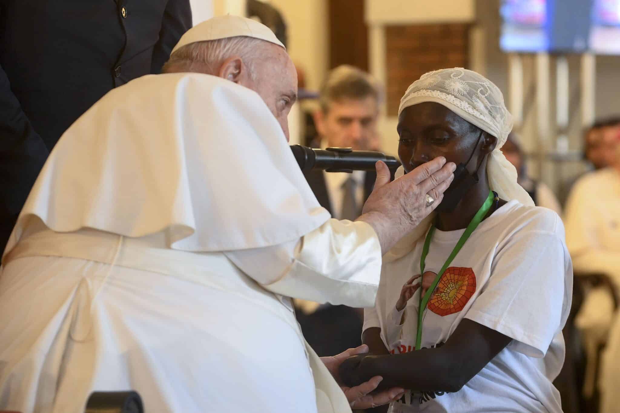 Pope Francis caresses the cheek of a woman whose hand was amputated in the violence that continues to plague the eastern part of Congo. The pope met victims of violence Feb. 1, 2023, at the apostolic nunciature in Kinshasa. (CNS photo/Vatican Media)