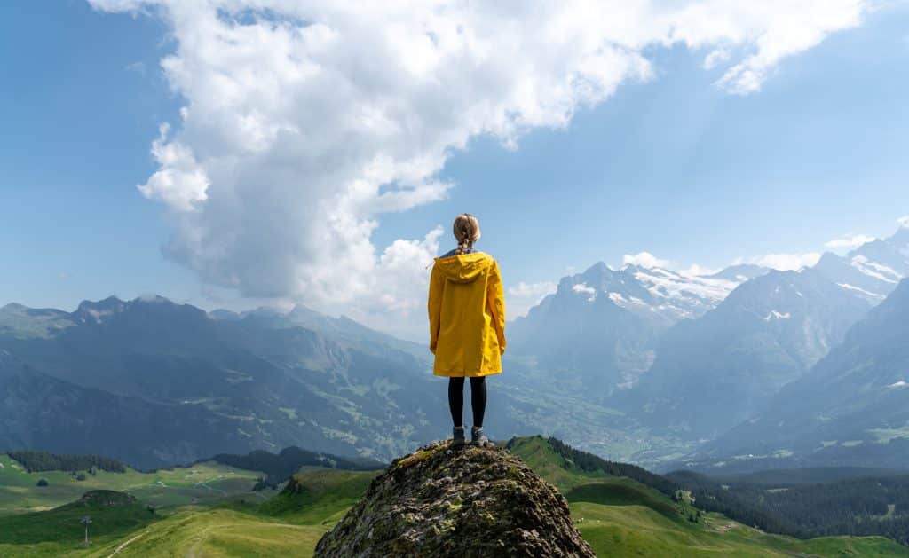 Woman stands on a cliff | Photo by lucas wesney on Unsplash