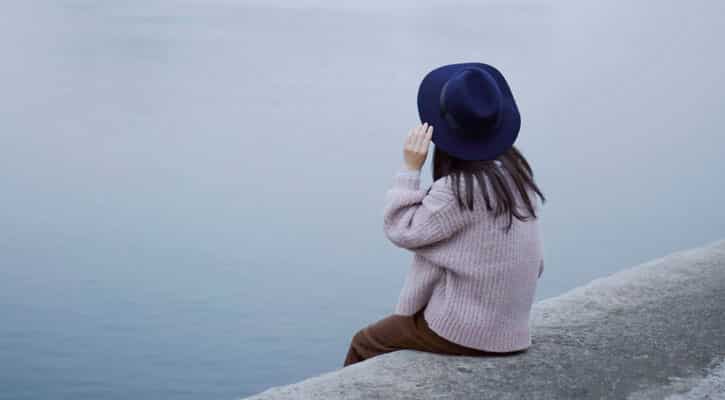 Woman with blue hat, looking at water