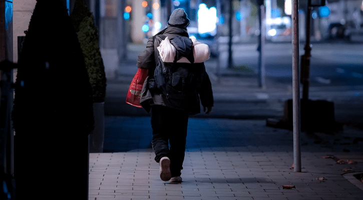 homeless person walking at night