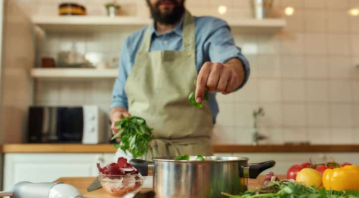 Man in kitchen making soup