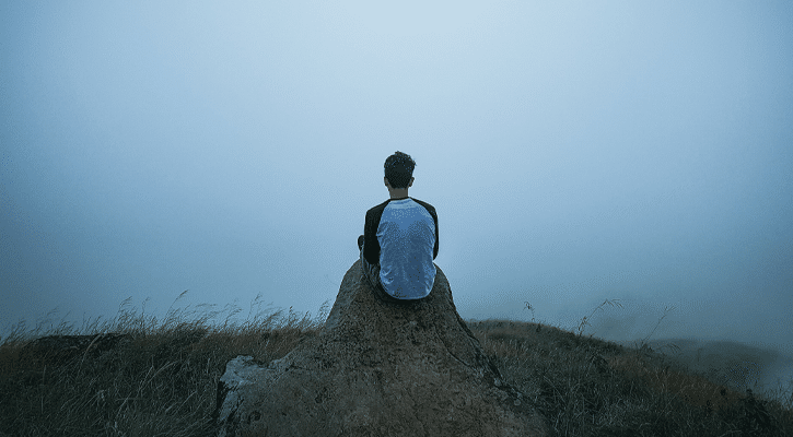 young man sitting on a rock