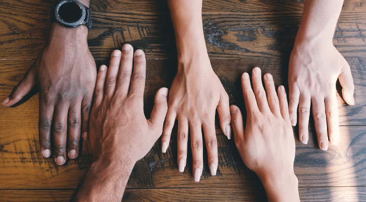 five hands on wood tabletop