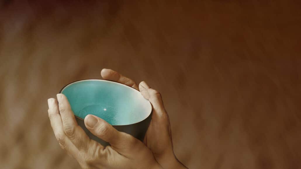 Hands holding up an empty bowl symbolizing want and poverty