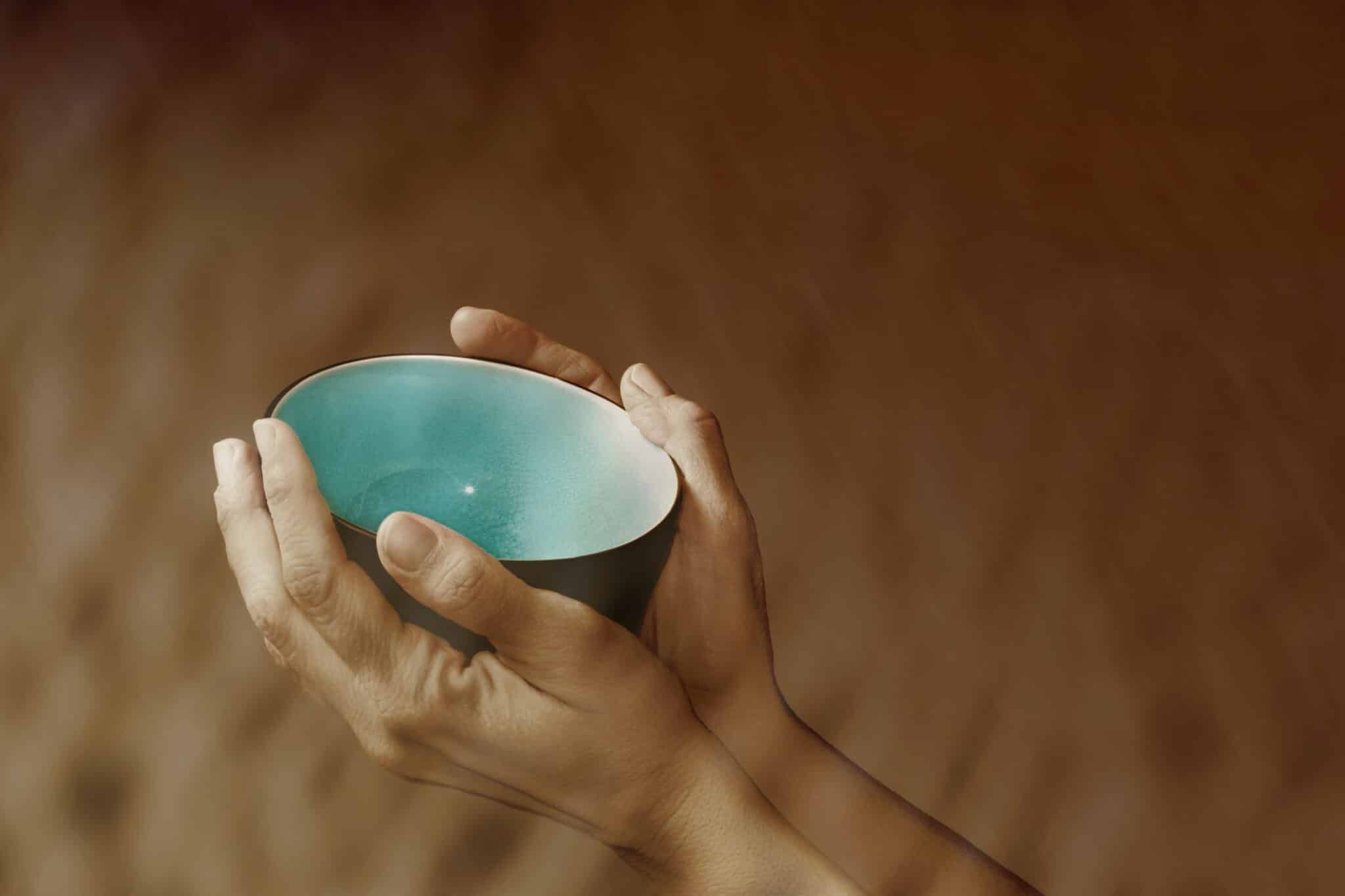 Hands holding up an empty bowl symbolizing want and poverty