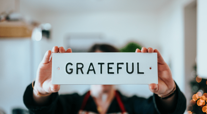 person holding sign that says grateful