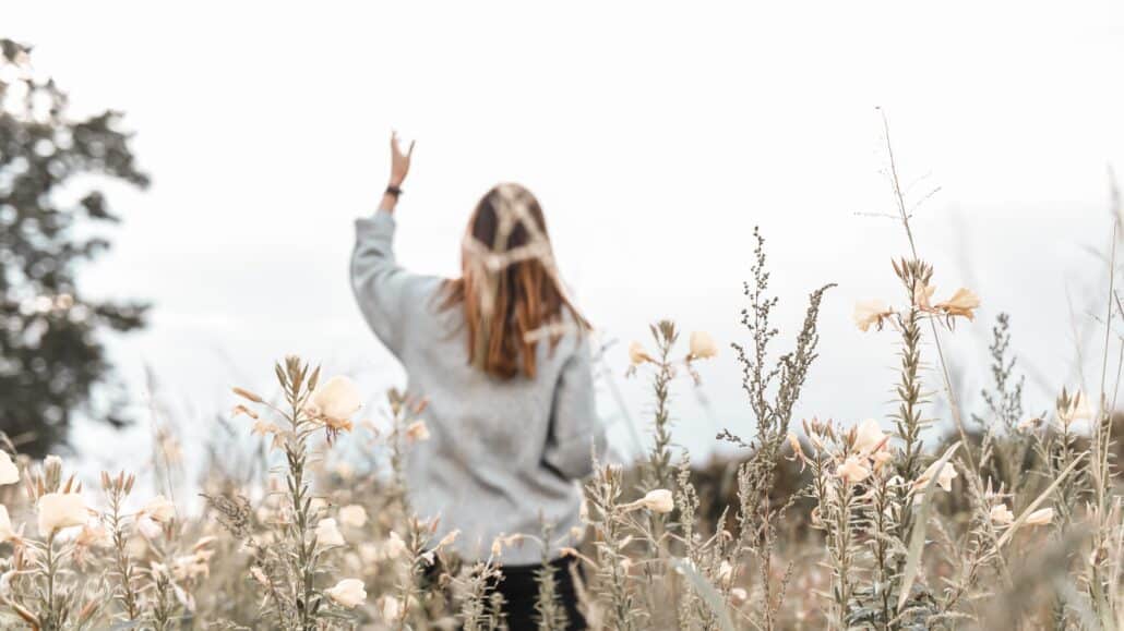 Woman walking through a field | Photo by Jasmin Ne on Unsplash