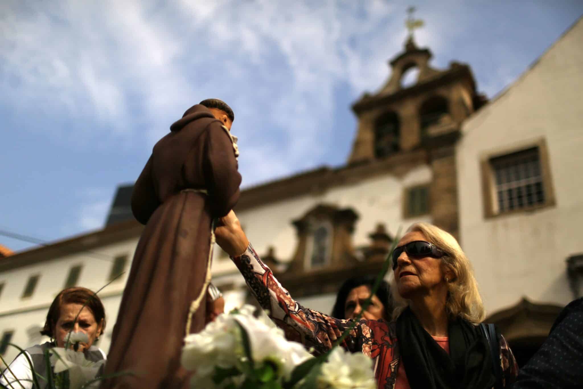 People pray in front of a statue of St. Anthony at a convent in Rio de Janeiro on the feast of St. Anthony of Padua June 13. (CNS photo/Pilar Olivares, Reuters)