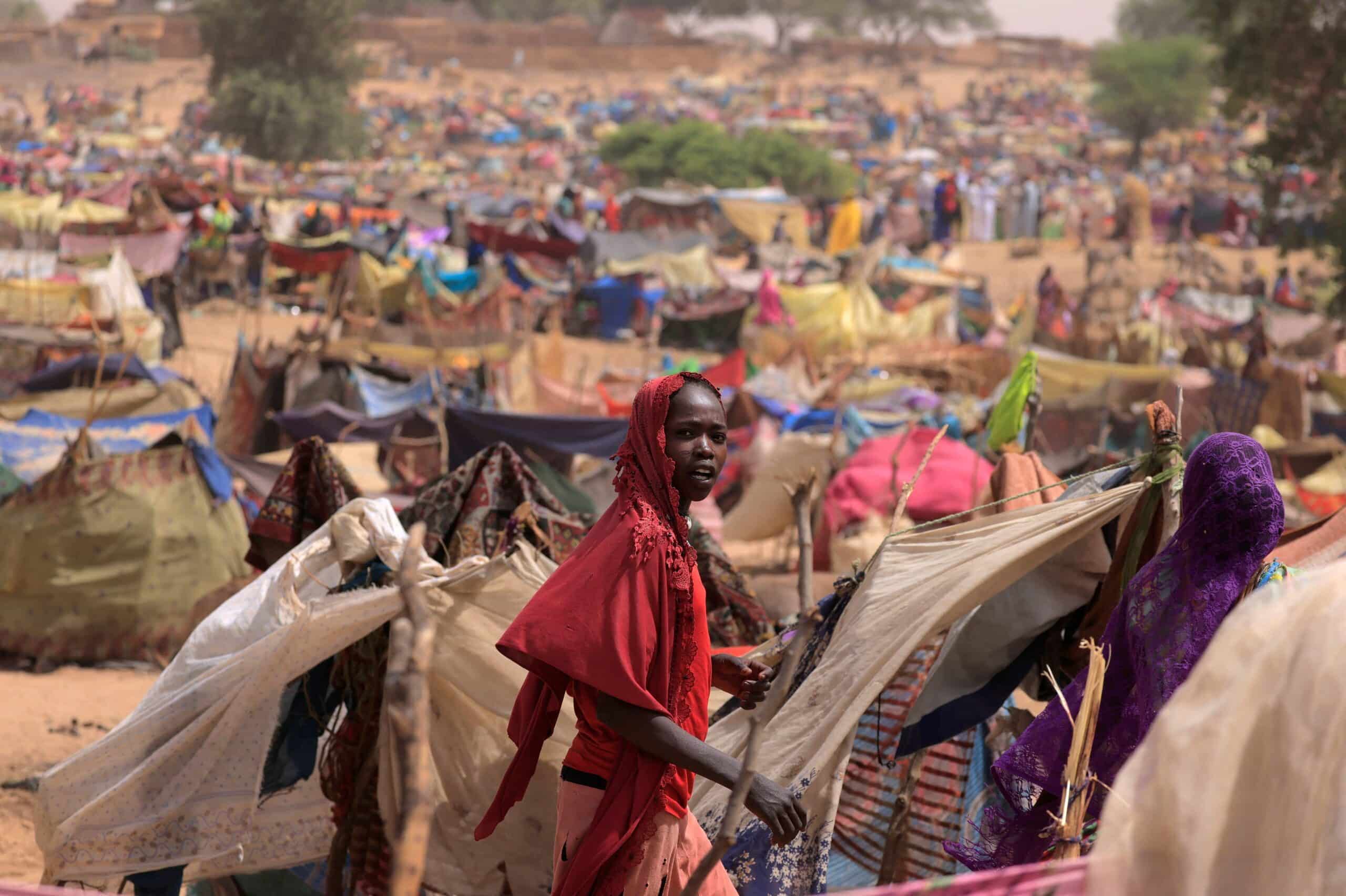 A young Sudanese woman who fled the conflict in Sudan's Darfur region, and was previously internally displaced in Sudan, moves past makeshift shelters, near the border between Sudan and Chad, while taking refuge in Borota, Chad, May 13, 2023. (OSV News photo/Zohra Bensemra, Reuters)