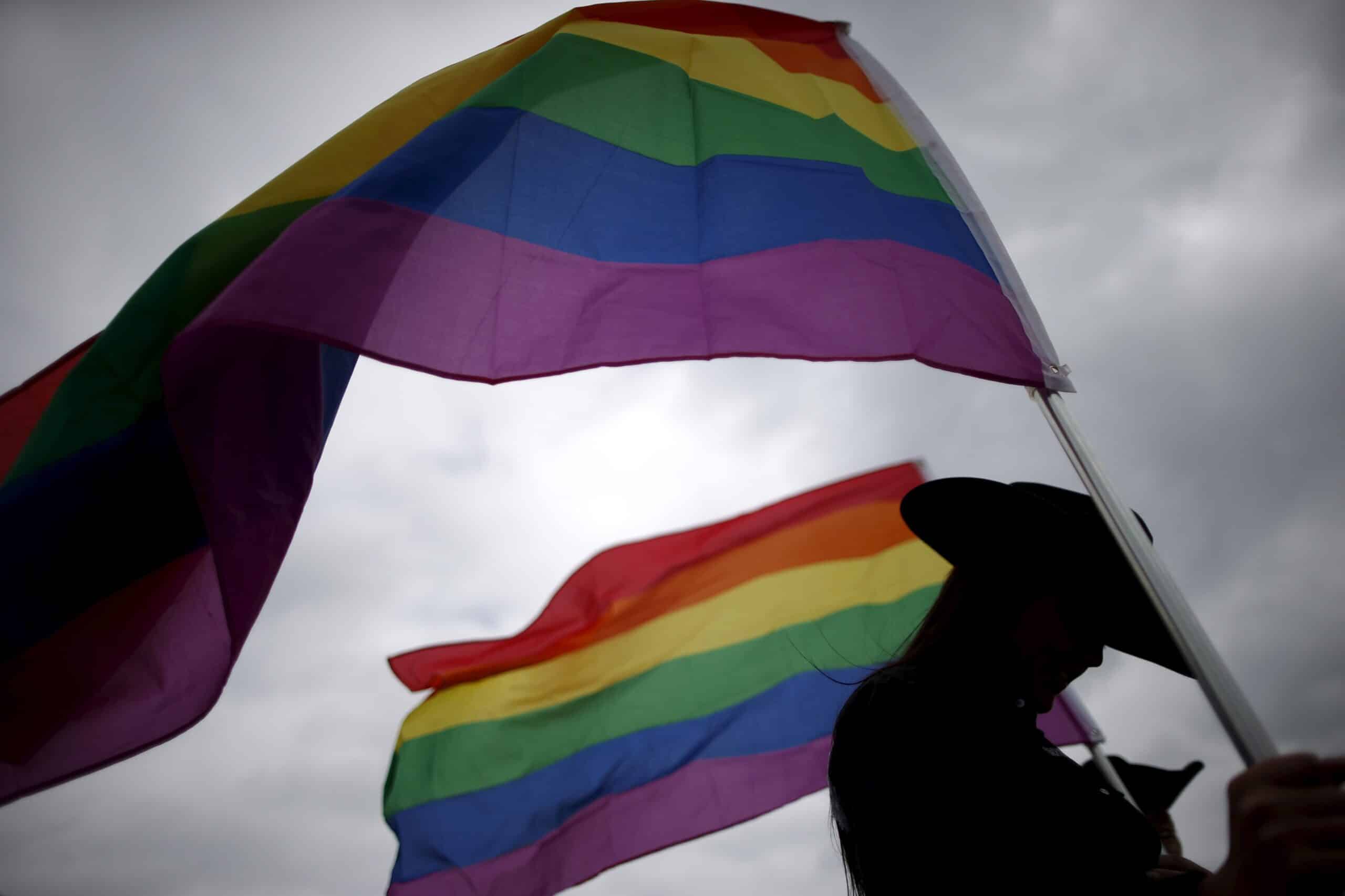 A woman is pictured in a file photo holding rainbow flags for the grand entry at the International Gay Rodeo Association's Rodeo In the Rock event in Little Rock, Ark. A federal judge June 20, 2023, struck down an Arkansas ban on some transgender surgeries or hormonal interventions for minors as unconstitutional. (OSV News photo/Lucy Nicholson, Reuters)