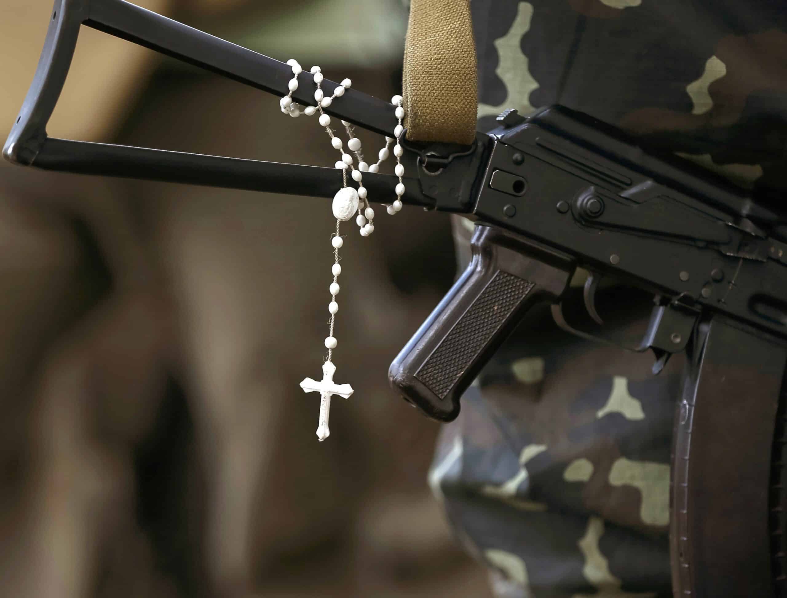 A rosary is pictured hanging from a machine gun in an undated file photo as Ukrainian soldiers stand at their positions near the Ukrainian town of Pervomaysk. Dorian Kernytsky, a Philadelphia-area Ukrainian Catholic, has been making hundreds of rugged, stainless steel rosaries for troops in Ukraine, hoping to provide solace amid the horrors of the current war with Russia. (OSV News photo/Gleb Garanich, Reuters)