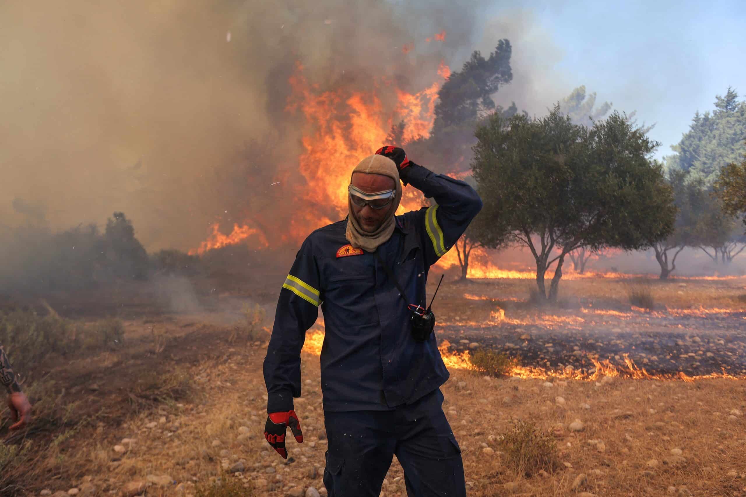 A firefighter walks next to rising flames as a wildfire burns near the village of Vati, on the island of Rhodes, Greece, July 25, 2023. (OSV News photo/Nicolas Economou, Reuters)