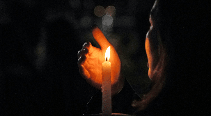 woman holding lit candle