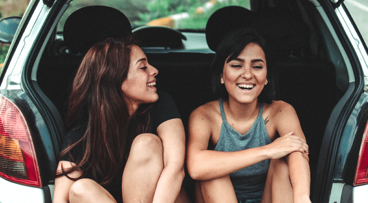 two woman laughing in car