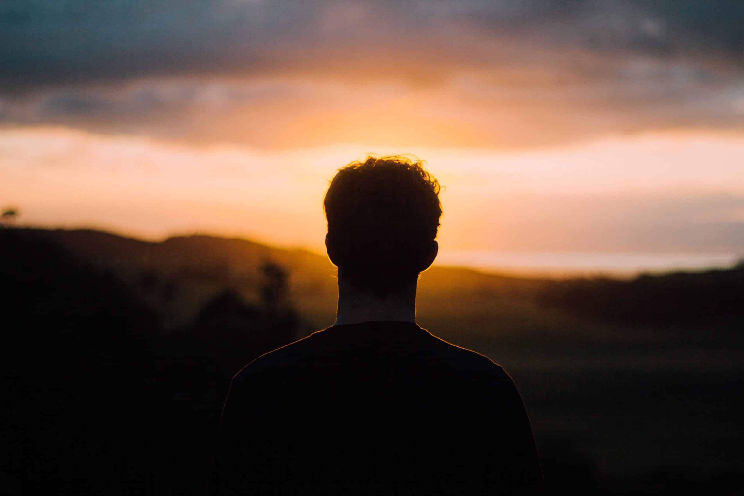 Man looking at sunset | Photo by Tim Marshall on Unsplash