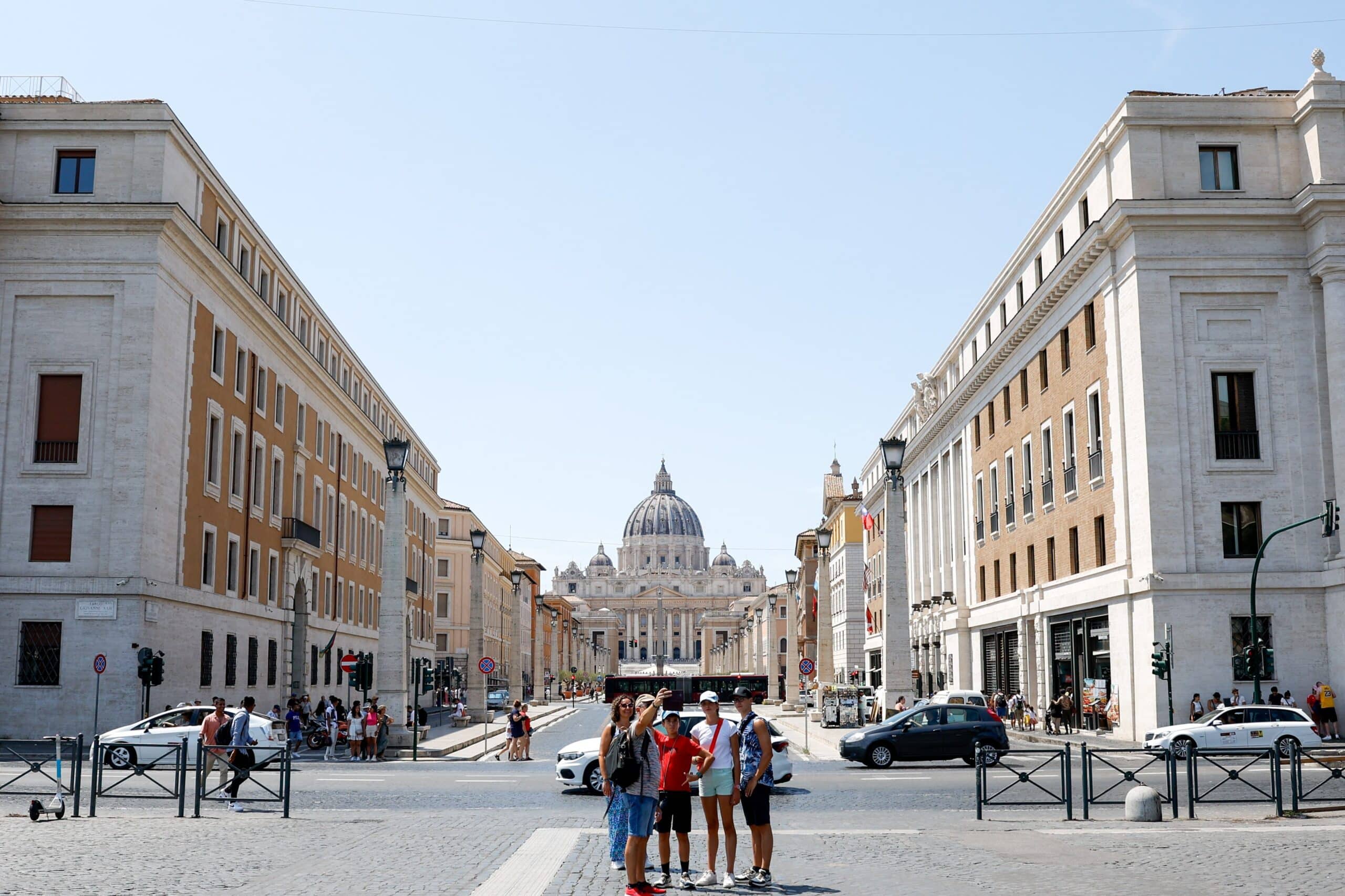 Visitors take a group photo in front of a roadway that separates Castel Sant'Angelo from Via della Conciliazione, the wide boulevard leading to St. Peter's Square in Rome July 30, 2023. On an average workday, some 3,800 vehicles travel this road each hour. The city of Rome plans to create an underground roadway for vehicle traffic with the aim of turning the entire area above ground into a car-free zone in time for Holy Year 2025. (CNS photo/Lola Gomez)