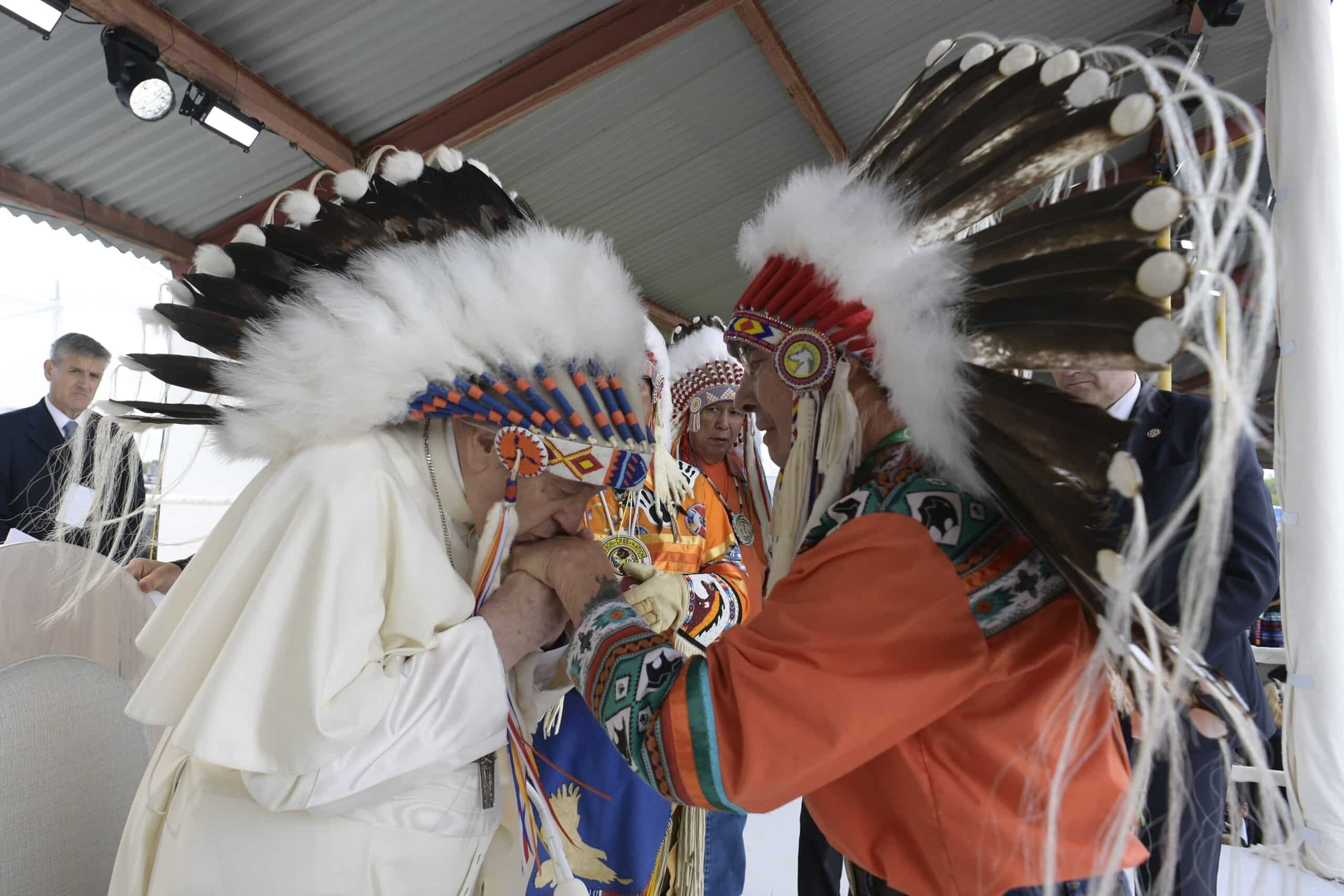 Pope Francis kisses the hand of an Indigenous leader