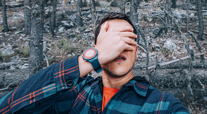 man holding his hands over his eyes.