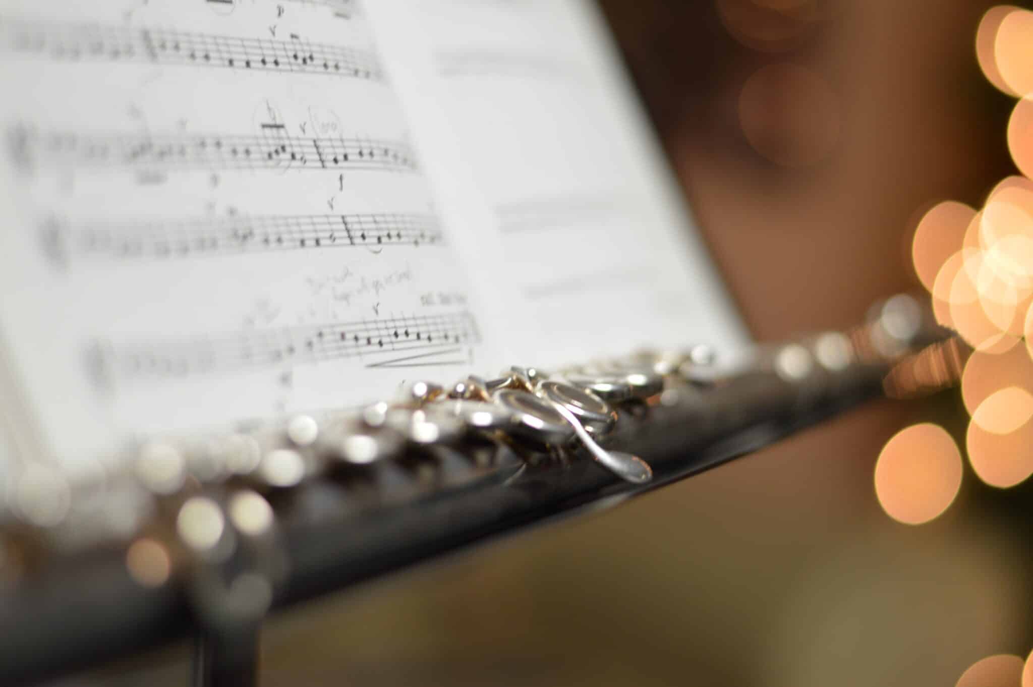 flute next to sheet music | Photo by Rajesh Kavasseri on Unsplash