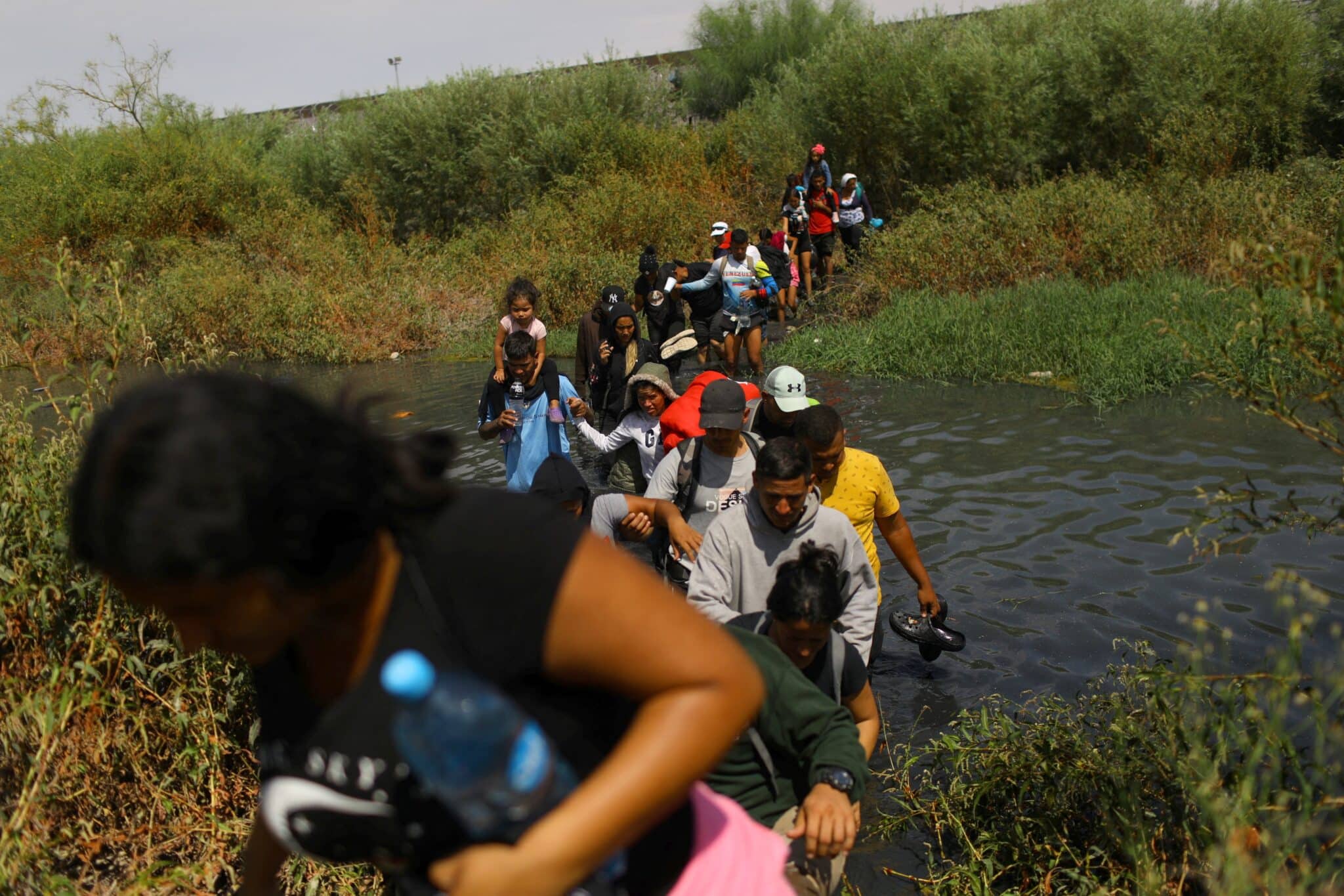 Migrants, mostly from Venezuela, are seen from Ciudad Juarez, Mexico, crossing the Rio Grande Sept. 21, 2023, to return to Mexico from the United States, after members of the U.S. Texas National Guard extended razor wire to inhibit migrant crossing. The group planned to seek asylum in the U.S. (OSV News photo/Jose Luis Gonzalez, Reuters)