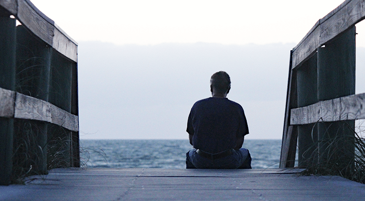 Person sitting quietly by water