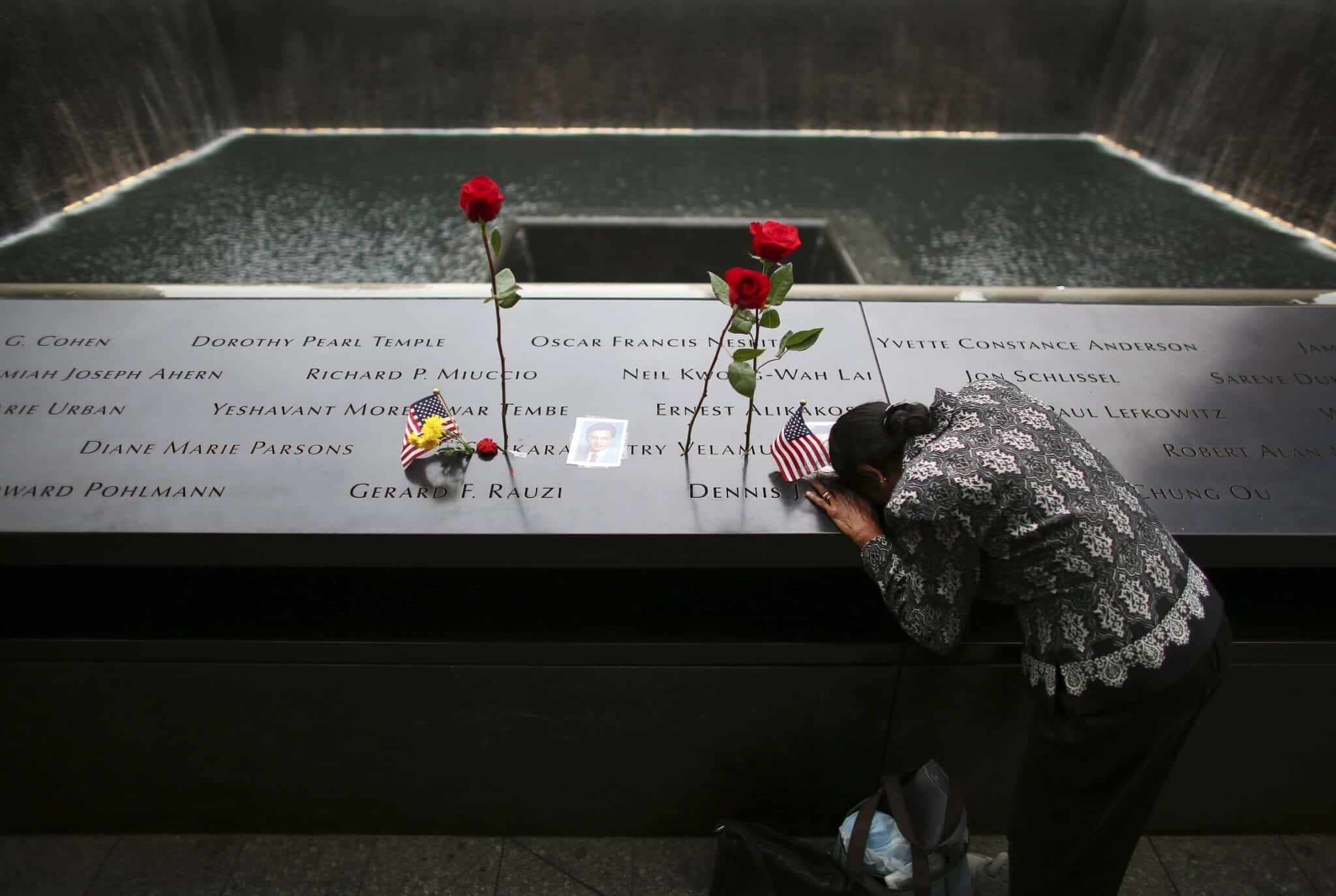 A woman grieves at the inscription of her late husband's name at the national 9/11 Memorial and Museum in New York City Sept. 11, 2014. (OSV News photo/Chang Lee, Reuters)