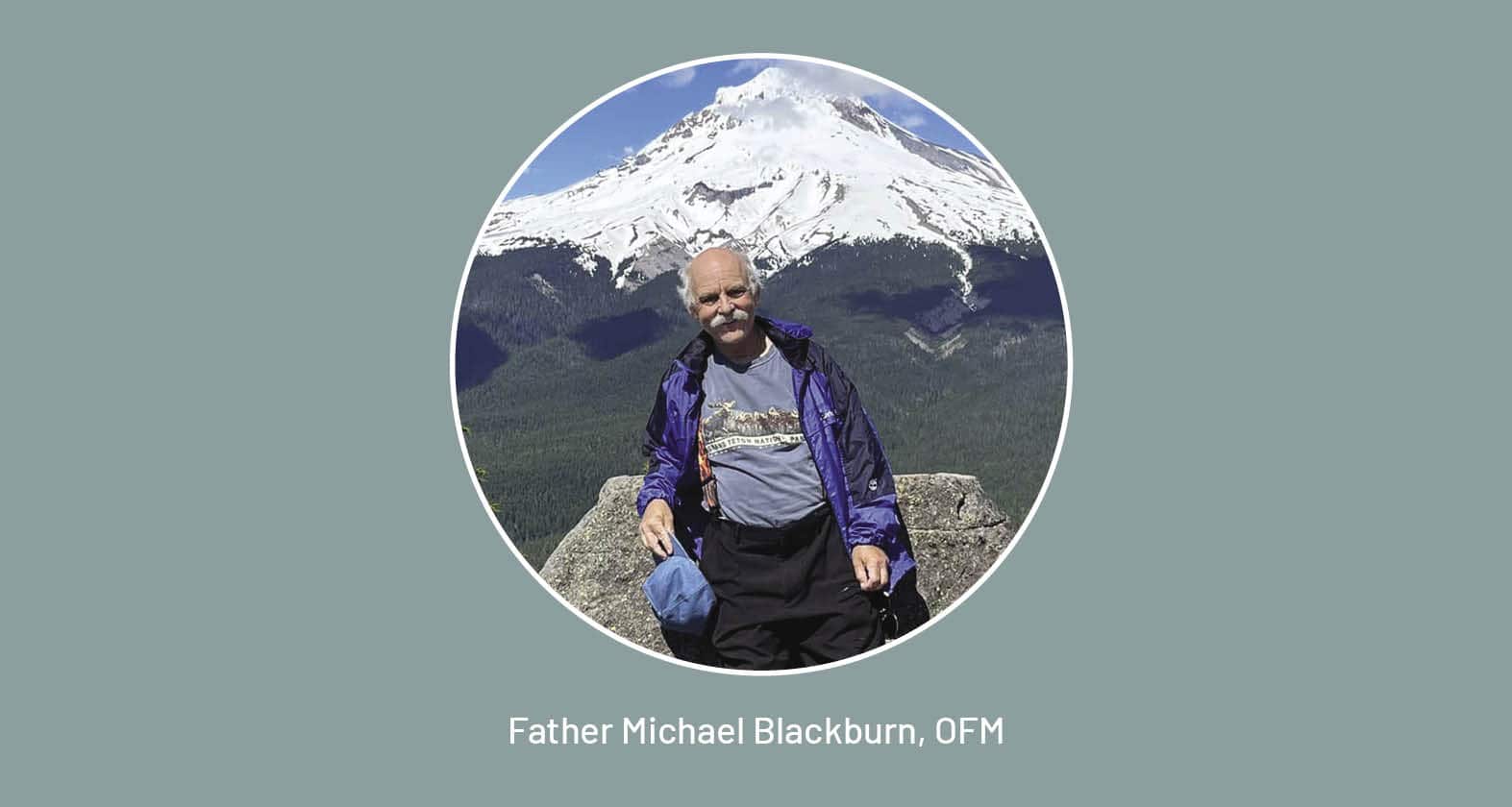 Michael Blackburn, OFM, stands in front of a mountain