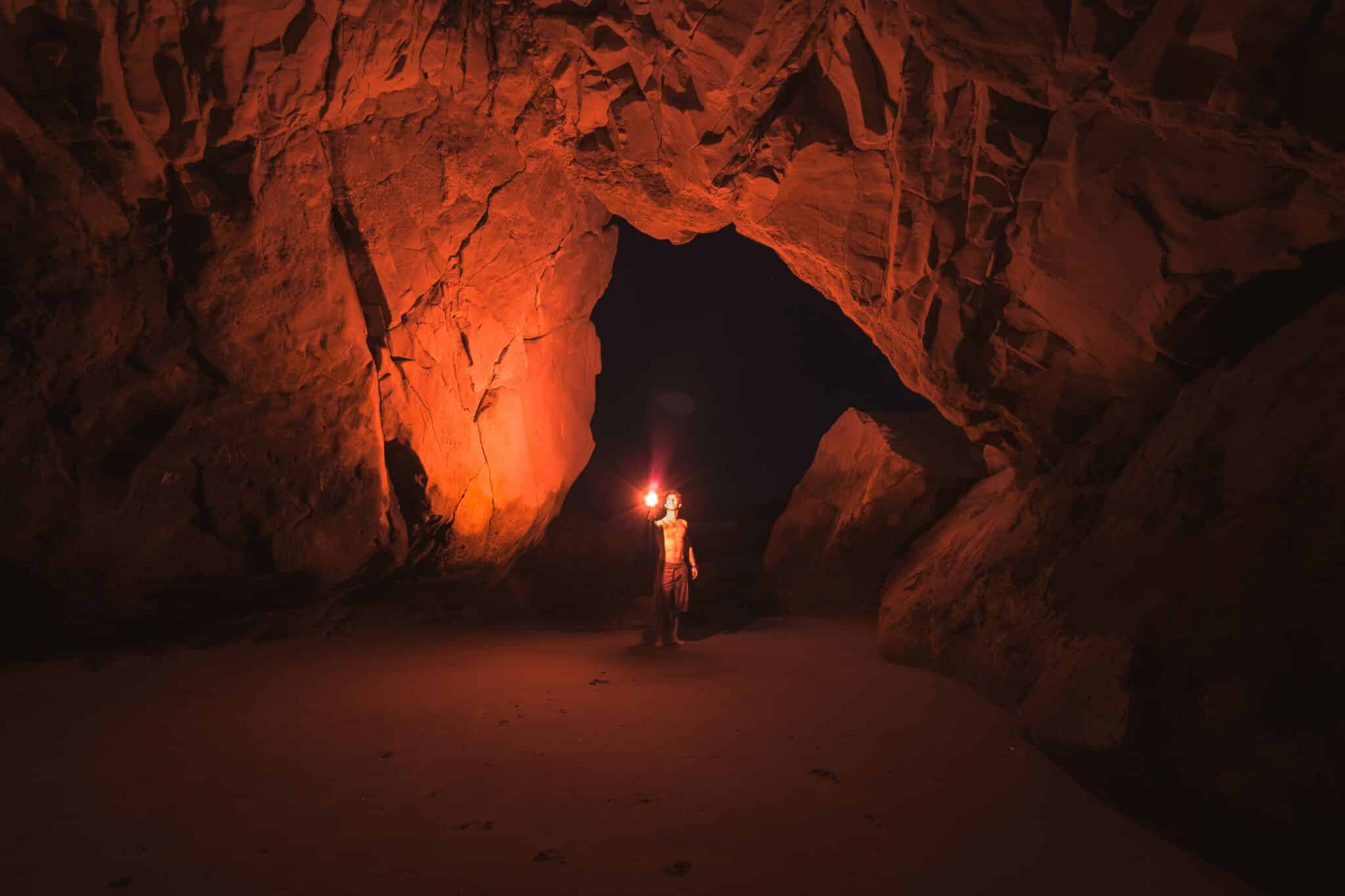 man in a cave | Photo by Jeremy Bishop on Unsplash