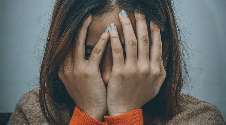 woman covering her face.