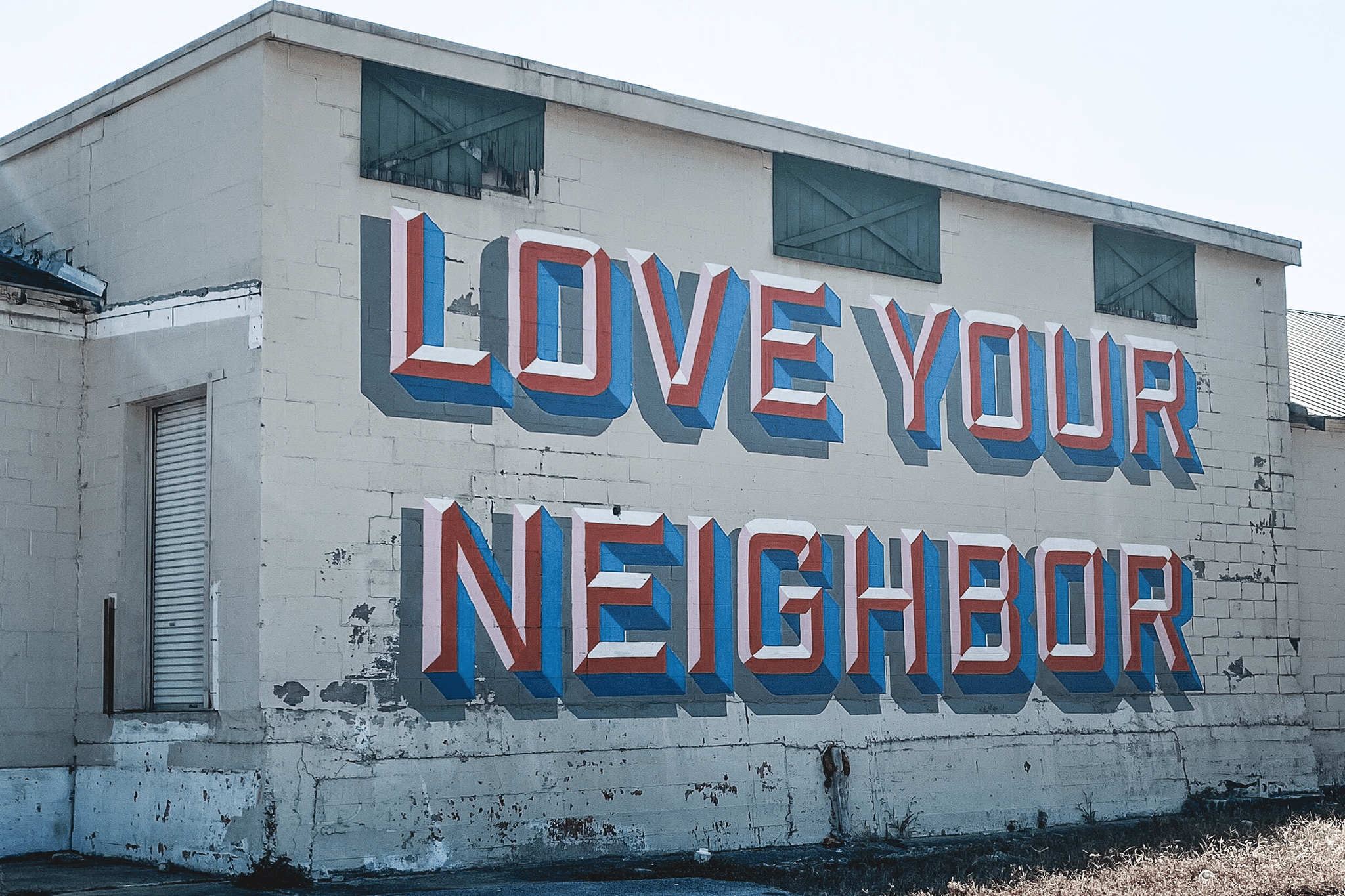 Love your Neighbor graffiti on side of building