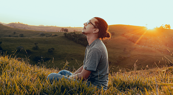 man sitting in peaceful field