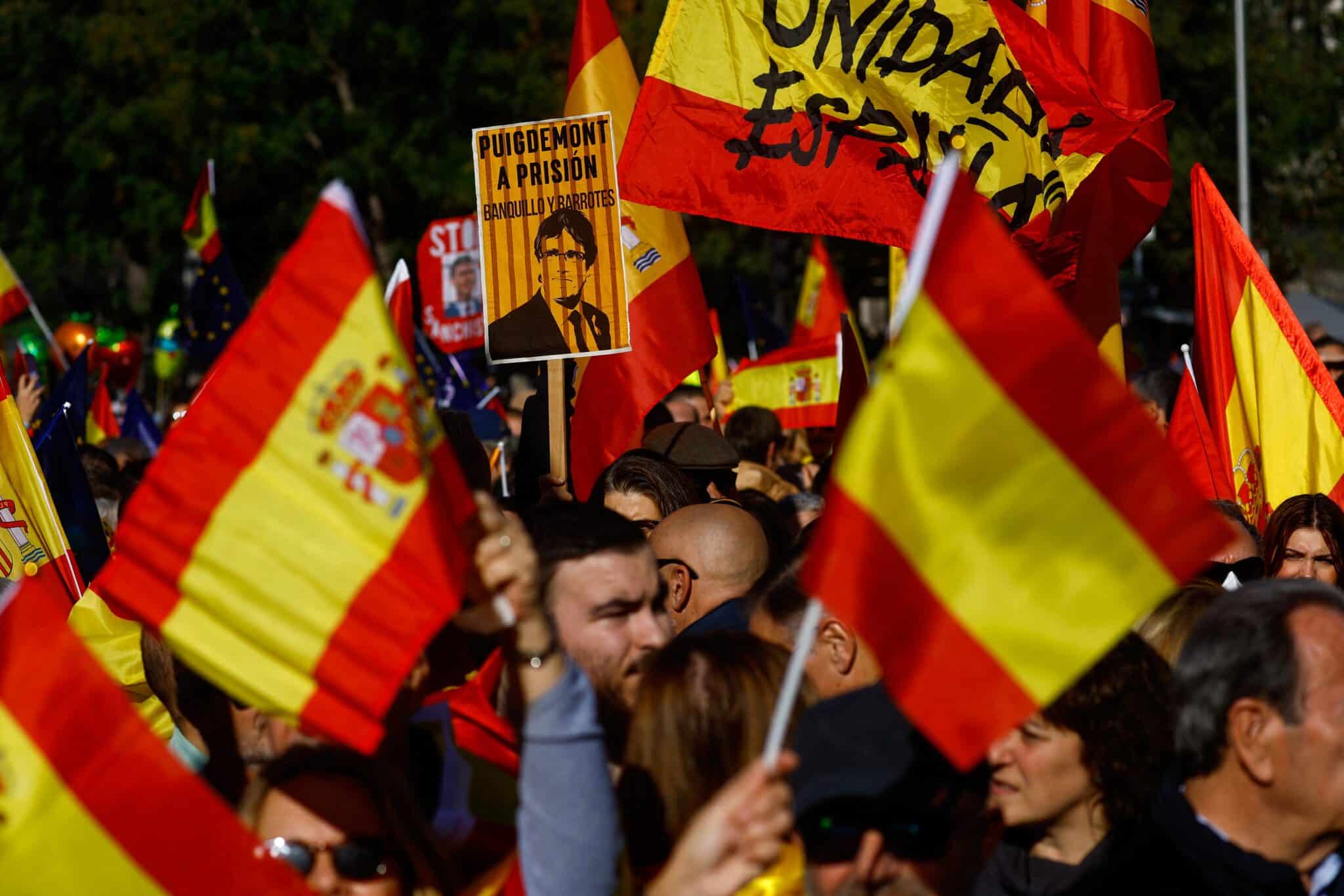 People hold Spanish flag flies as they take part in a in Madrid's Cibeles Square Nov. 18, 2023, after Spain's socialists reached a deal with the Catalan separatist Junts party for government support, which includes amnesties for people involved with Catalonia's failed 2017 independence bid. (OSV News photo/Susana Vera, Reuters)