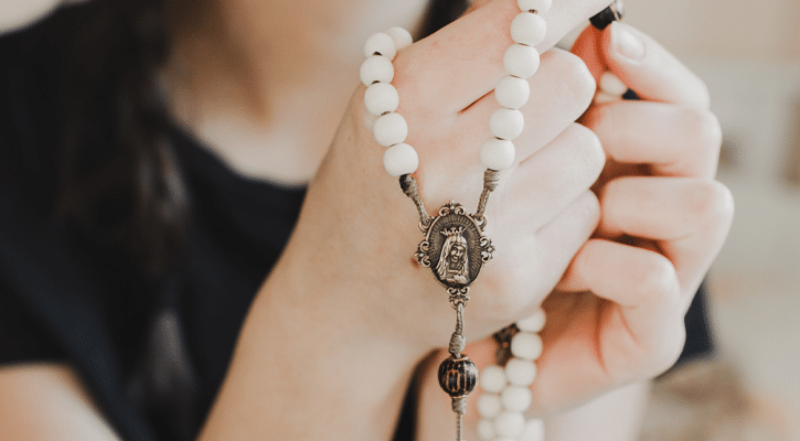 woman holding rosary in her hands