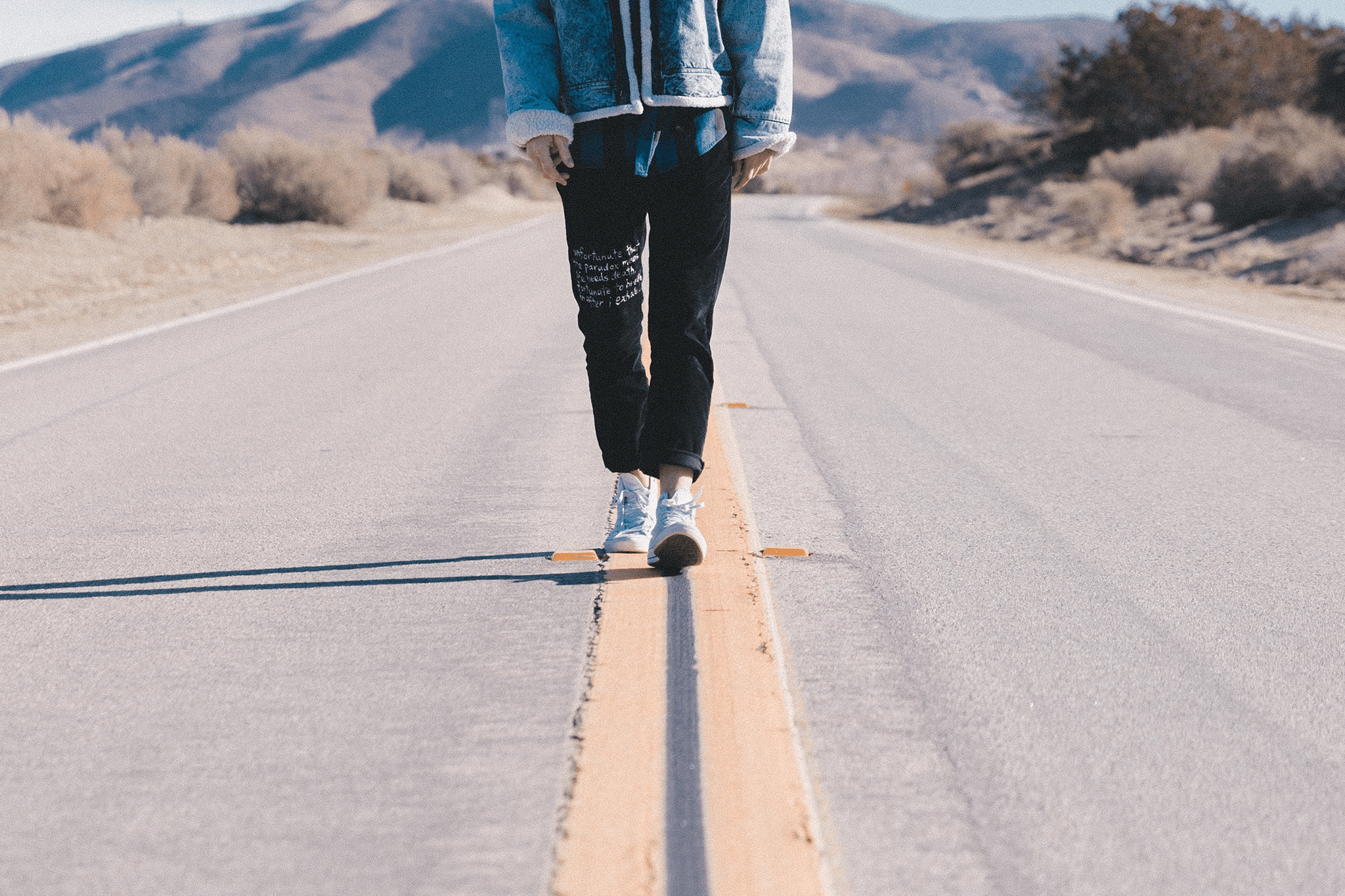 person walking in between the road lines.