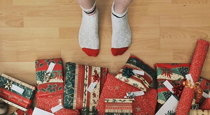 person standing in front of wrapped gifts.