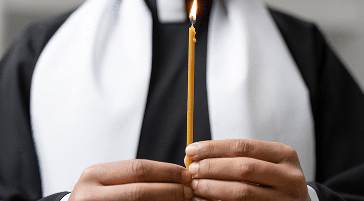 priest holds candle