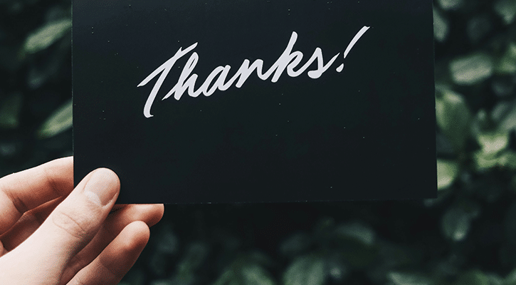 person holding a thank you card.