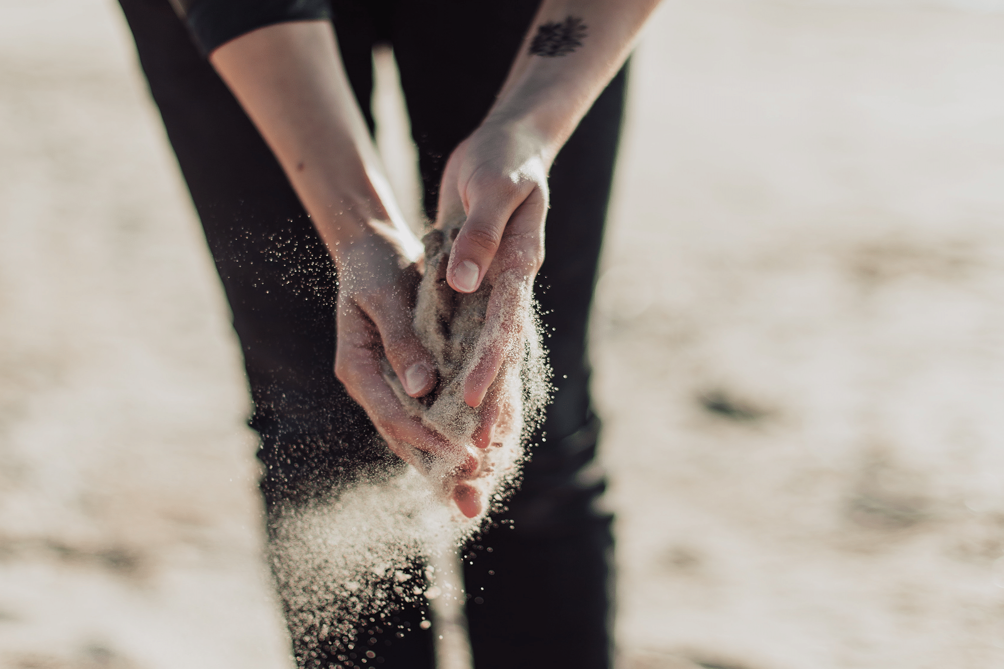 Sand blowing out of hands.