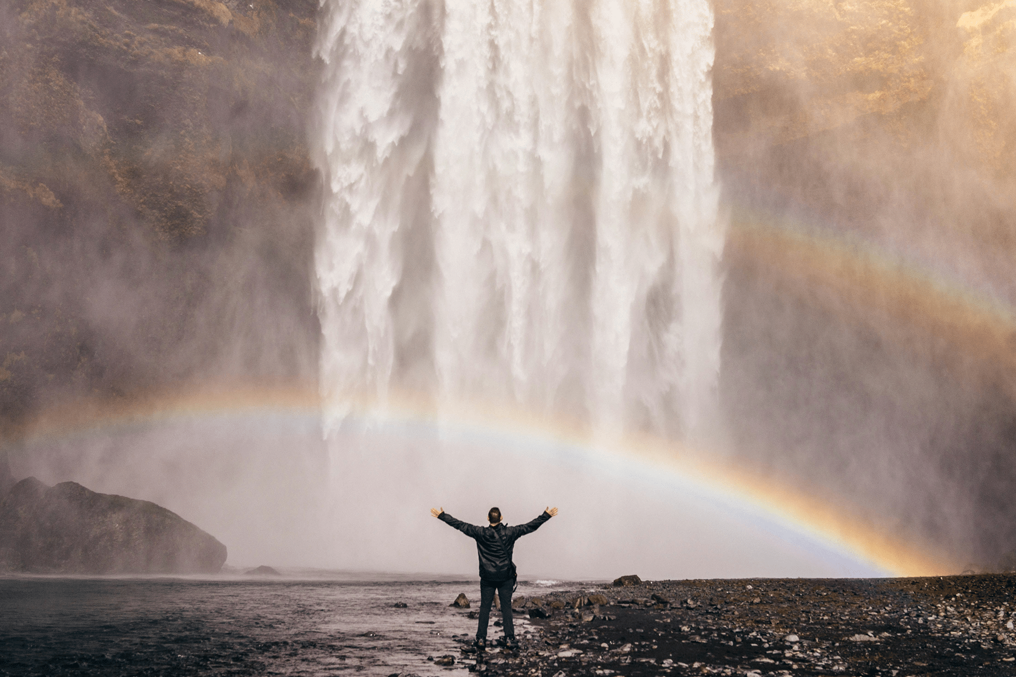 person standing under a waterfall