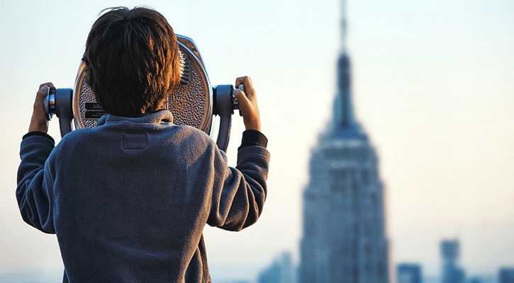 person focusing through binoculars